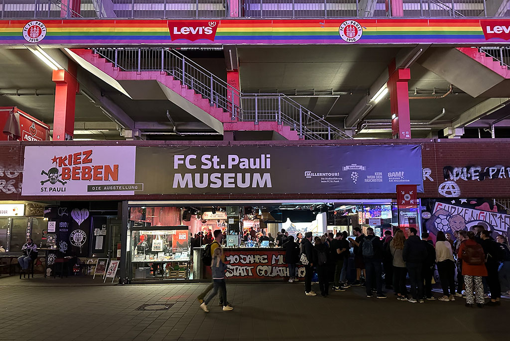 auf diesem Foto ist das FC St. Pauli-Museum von außen zu sehen. Eine große Gruppe Menschen steht davor.