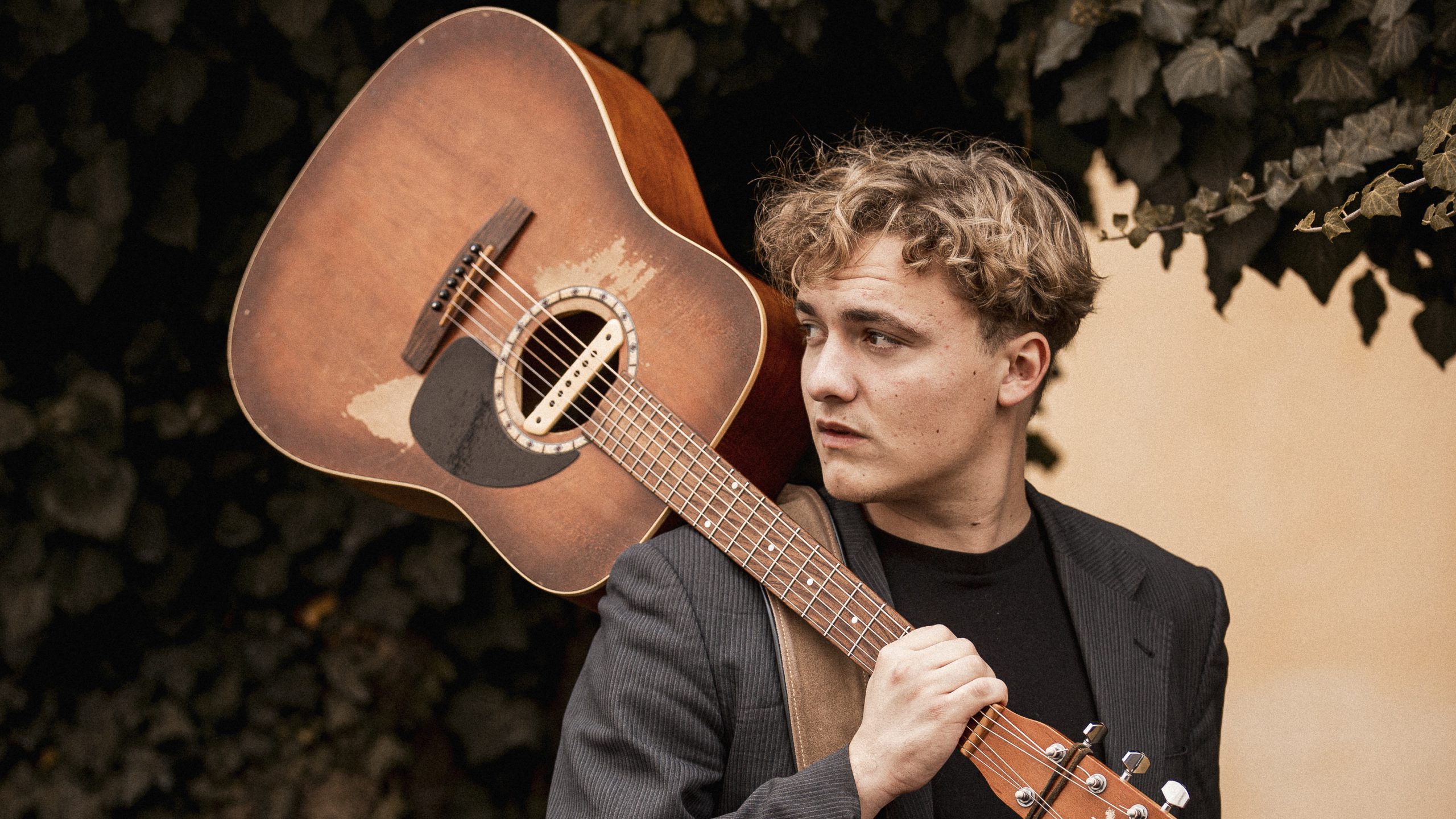Singer Songwriter Jakob Muehleisen mit seiner Gitarre auf der Schulter