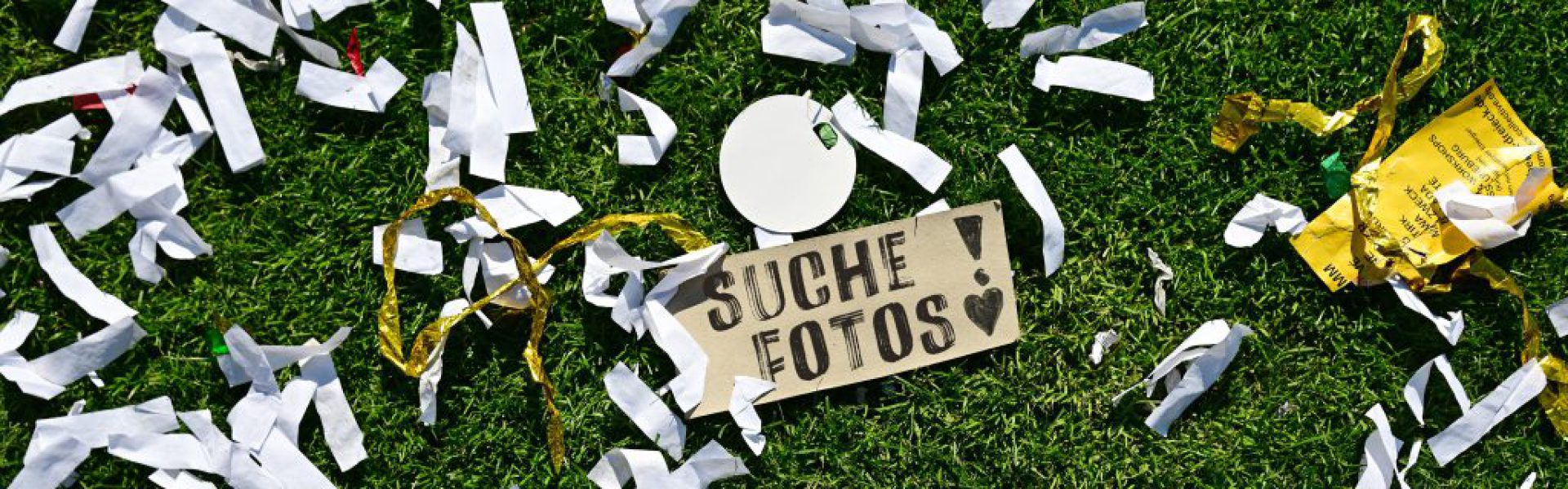 Ein Pappaschild mit der Aufschrift "Suche Fotos" liegt auf dem Rasen des Millerntorstadions.