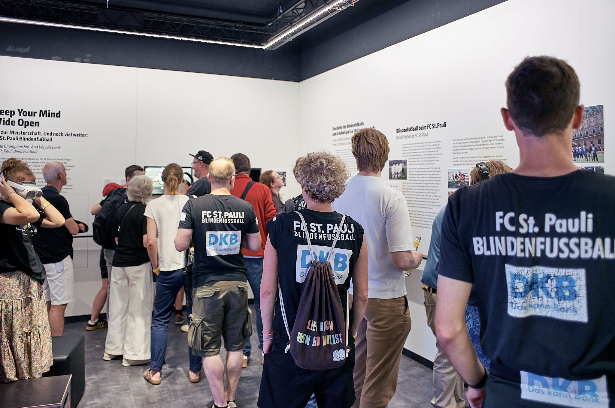 Viele Menschen stehen im Ausstellungsraum inmitten der Sonderausstellung und erkunden diese.