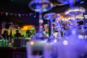 Event im FC St. Pauli-Museum am Millerntor. Menschen bestellen Gestränke am Tresen der 1910-Weinbar.